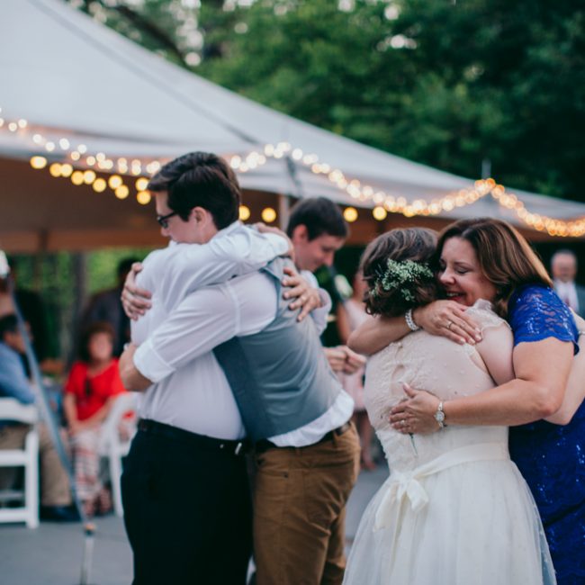 wedding couple hugging guests outside